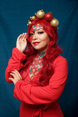 Woman with Christmas makeup, wearing headband with Christmas balls.