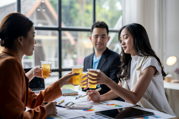 Business people clinking glasses with beer in office after work