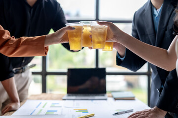 Business team celebrating success with drinks in the office