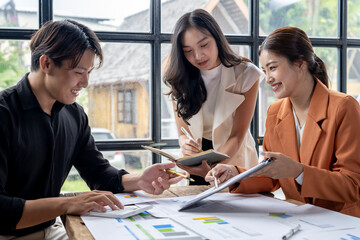 Asian business people team working on project using calculator and laptop in office together
