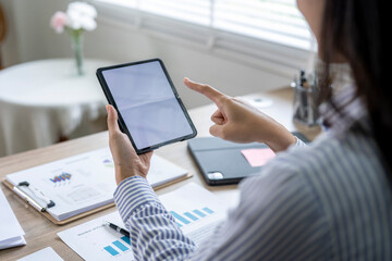 Businesswoman using digital tablet with blank screen working at office