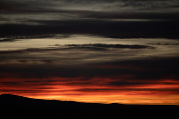 Dark grey and red cloudy mystical sunset in America