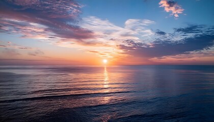 Fototapeta premium new beginning concept Beautiful orange sunset over the ocean. Reflected on the calm waters with a few clouds in the sky.