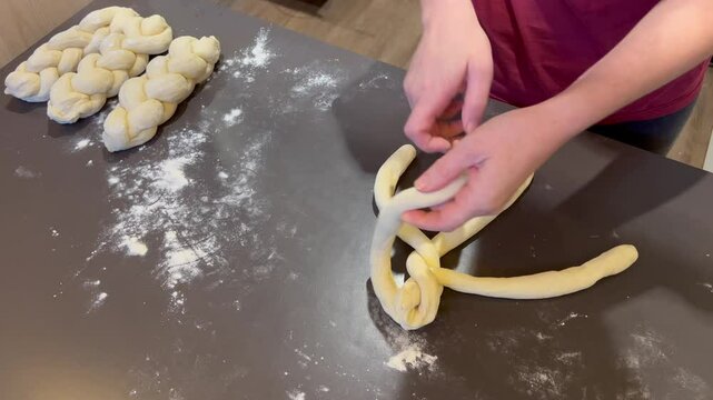 Hands of Jewish woman preparing Challah bread for sabbath holiday