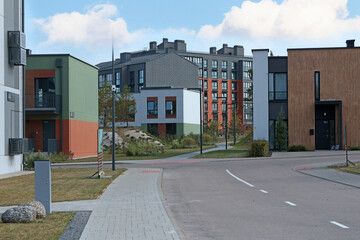 Modern apartment buildings and townhouses in residential complex. Road and lighting. Comfortable...