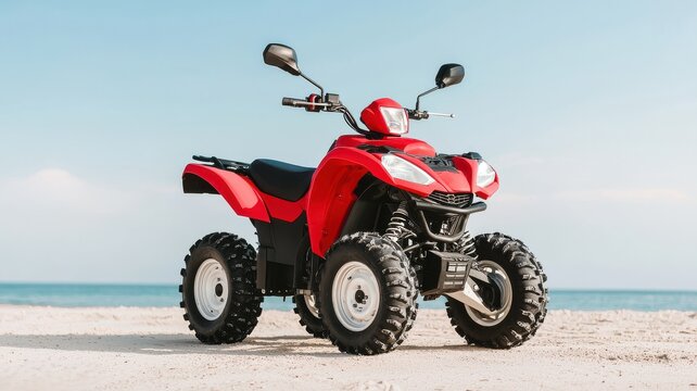 A vibrant red quad bike parked on a sandy beach with a clear blue sky in the background, ideal for outdoor adventure themes.
