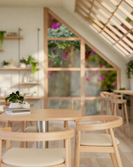 A minimal wooden table with armchairs in a beautiful, cozy Scandinavian coffee shop seating area.
