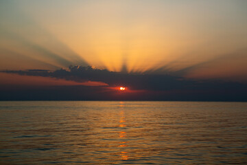 Stunning sunset at sea, bright colors reflecting on water.