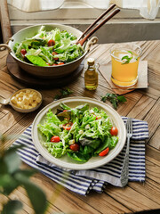 Healthy assorted vegetable salad with avocados and tomatoes, served in a bowl with diced cheese and an option of olive oil
