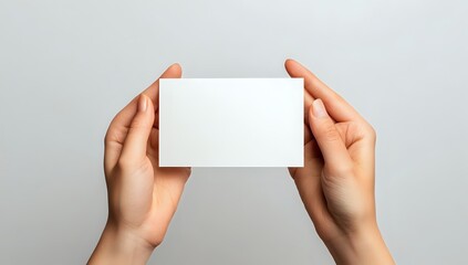 Close-up of two hands holding a blank white card.