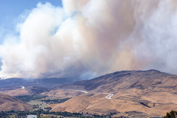 Valley south of Reno. I-580 highway follows the hills with a huge smoke column rising above it