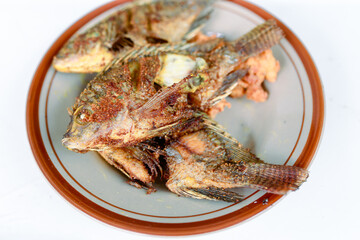 Fried fish served on a white plate. isolated on white background.