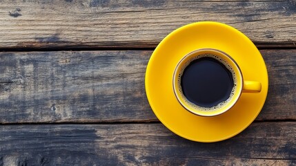 Yellow cup of hot coffee on a wooden background, close-up.