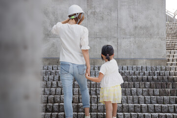 災害、防災訓練のイメージ。階段を登る女性と子供