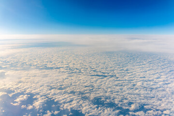 View from the airplane window at a beautiful cloudy sky and the airplane wing