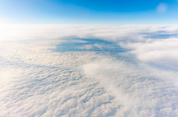 View from the airplane window at a beautiful cloudy sky and the airplane wing