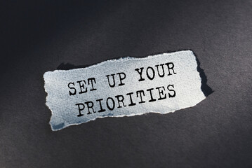 A torn piece of paper with the words Set Up Your Priorities written on it.