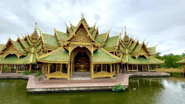 4K video footage of Pavilion of the Enlightened, a green temple complex in Muang boran Ancient city, Samut Prakan, Bangkok, Thailand. Famous green and gold roof structure, surrounded by a lake.