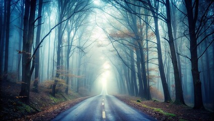 Fototapeta premium Spooky and desolate forest road shrouded in thick fog invoking a sense of mystery and solitude