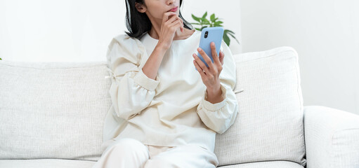 携帯を持ち悩む女性 © ponta1414