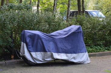 Motorcycle covered with a cover in bad weather