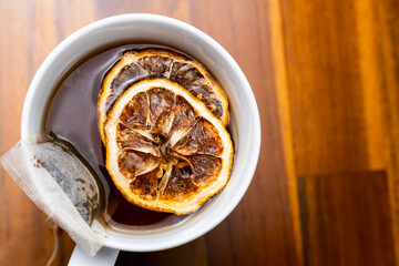 cup of tea with dried lemon slice, on a wooden table
