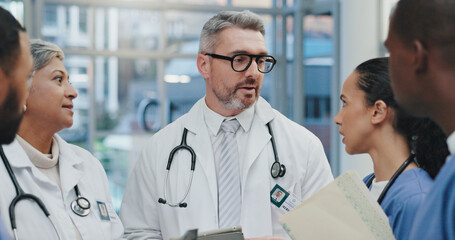 Discussion, nurses and doctors in hospital with clipboard, meeting and advice for schedule in lobby. Group, men and women together in healthcare for planning, consulting and medical team in clinic