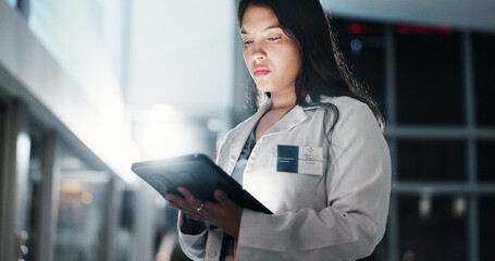 Woman, doctor and night with tablet for research, medical data or new discovery at hospital. Young,...