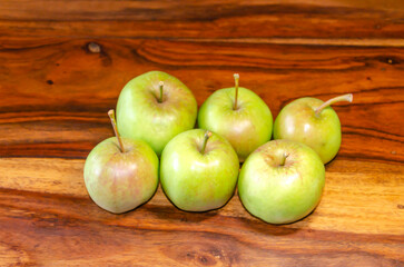 Green apples sitting on a wooden table