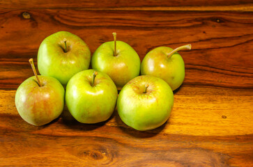 Green apples sitting on a wooden table