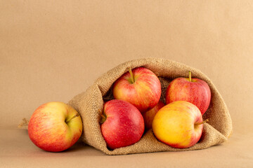Several red apples in a jute bag on kraft paper, macro.