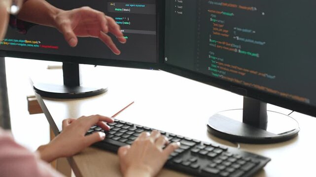 Slow motion back end or software developer manager supervising his team on new application program development on debugging and solving complex code algorithms on monitor. Burgeoning