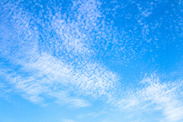 Cloudy blue sky background. Clouds in the summer sky. Natural wallpaper idea concept.	