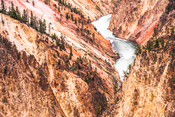 A river winding through a rugged canyon with red and orange hues.