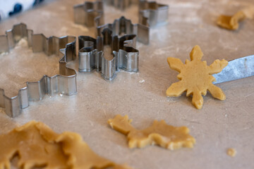 Close-up of snowflake-shaped cookie dough with metal cutters