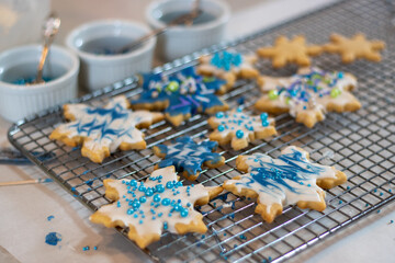 Snowflake-shaped cookies with blue and white icing and sprinkles