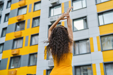 Woman stretching by yellow building
