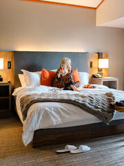 Mature female relaxing in bed vacationing at Salish Lodge and Spa