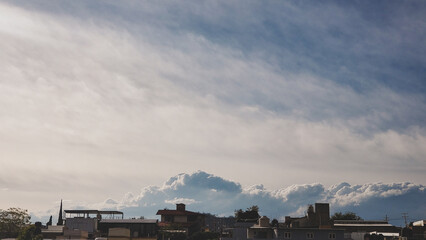 View of a blue cloudy sky over city landscape.