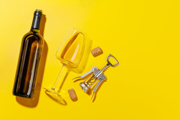 Wine glass, bottle alongside a corkscrew and several corks
