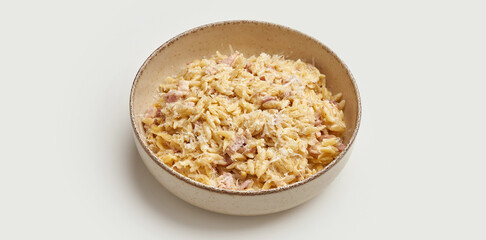 A bowl of creamy risotto is presented on a white background. The risotto is made with arborio rice, cooked until it is creamy and tender.