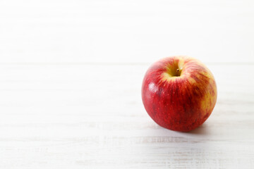 Ripe organic red apple on white table background.