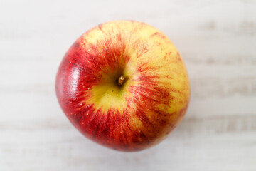 Ripe organic red apple on white table background.