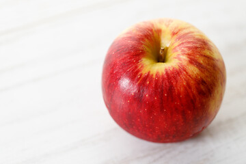 Ripe organic red apple on white table background.