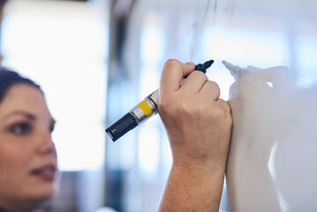School, classroom and teacher writing on whiteboard for lesson, learning and exam in university....