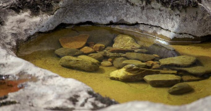 low angle close up shot of limestone Swiss cheese holes with water and gravel inside. On the river ure at the lower falls at Aysgarth falls, Yorkshire dales