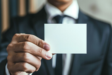 Fototapeta premium A man is holding a white business card