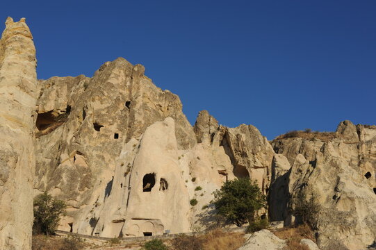 Landscape with caves in limestone (sandstone) mountains with rock-cut churches, chapels and monasteries and blue sky in summer in G&ouml;reme Open Air museum, Cappadocia, Anatolia, Turkey (G&ouml;reme &ouml;ren yeri