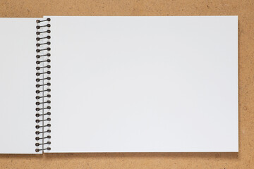 ketch book with spiral bound laying on wooden desk