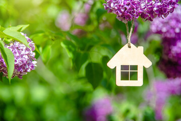Naklejka premium The symbol of the house among the branches of the pink lilac